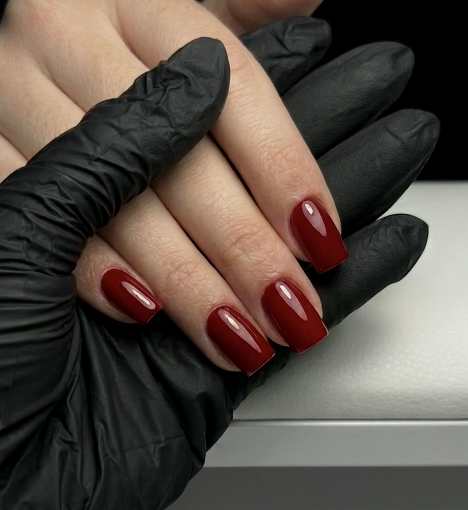 Deep red gel manicure on square nails, shaped with the e-file technique