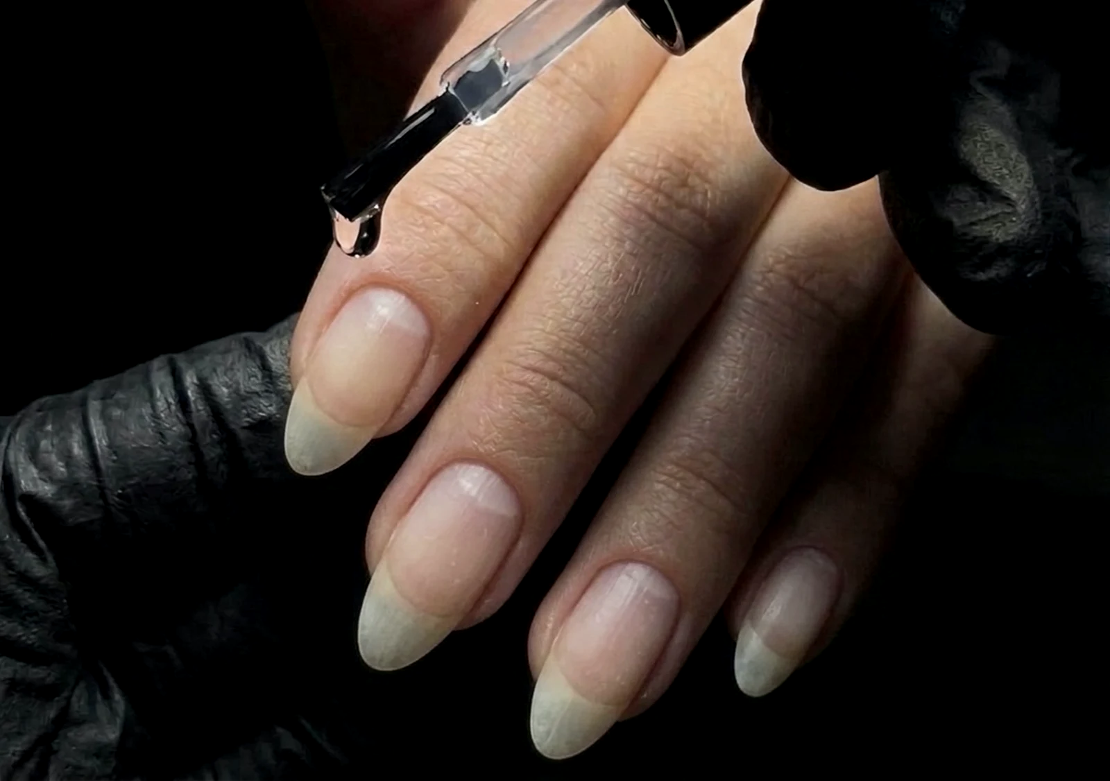 Natural nails being treated with IBX strengthening solution applied from a brush